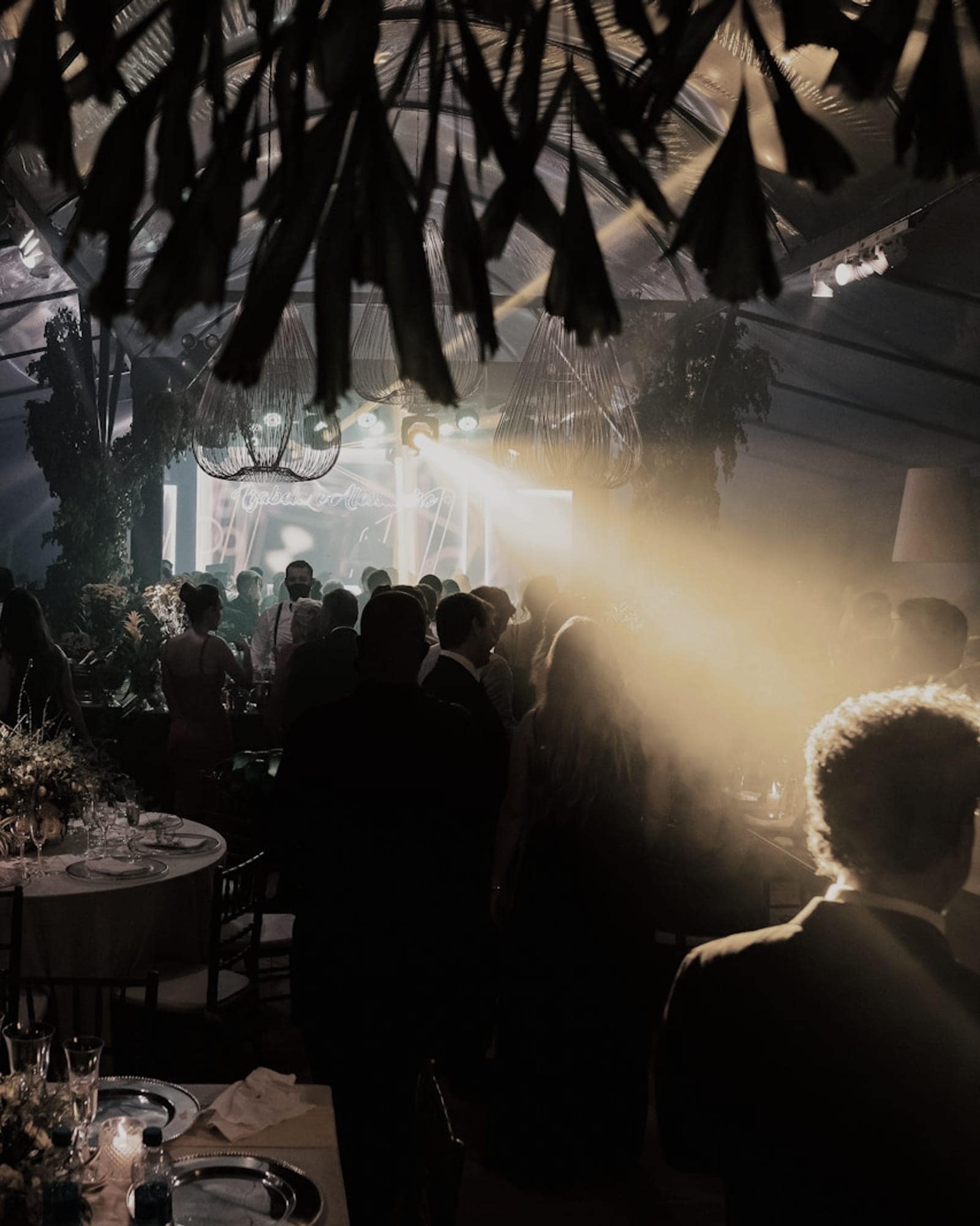 Abendveranstaltung in einer Halle mit gedeckten Tischen und Bühnenlicht
